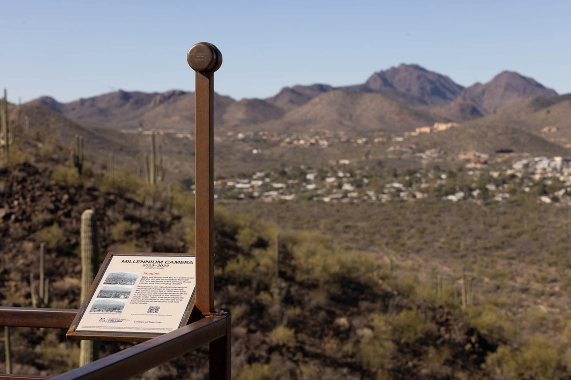 Image of a sign and art installation looking out at the mountains from Tumamoc Hill